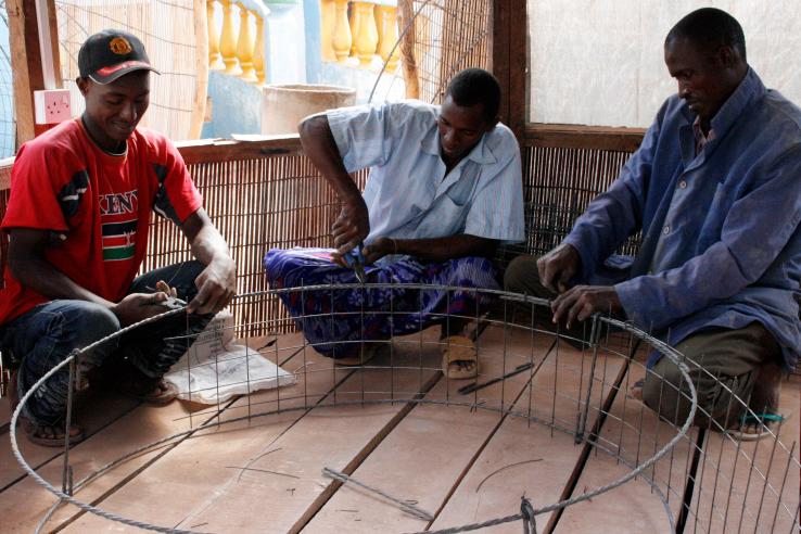 Three men assemble a metal well frame J-PAL Africa evaluation summary