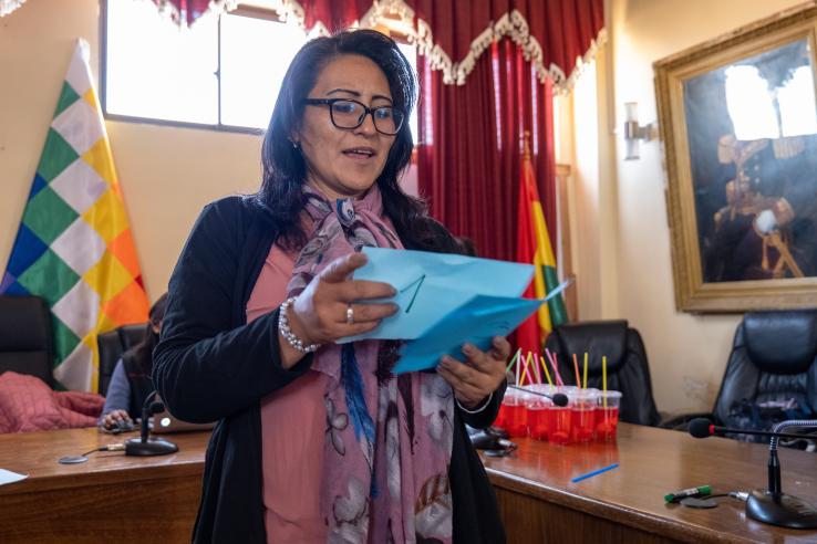 An OTB president reads from paper and explains public good provision in Bolivia.