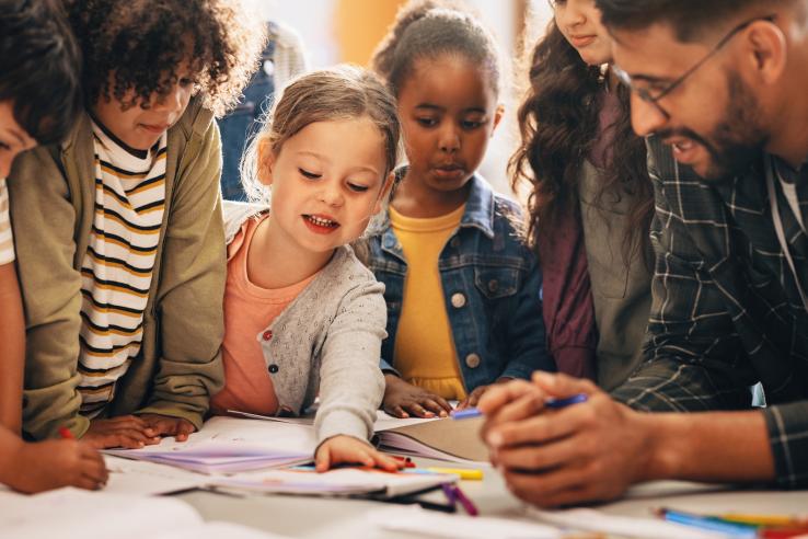 Elementary school students engage in group activity with teacher in the United States