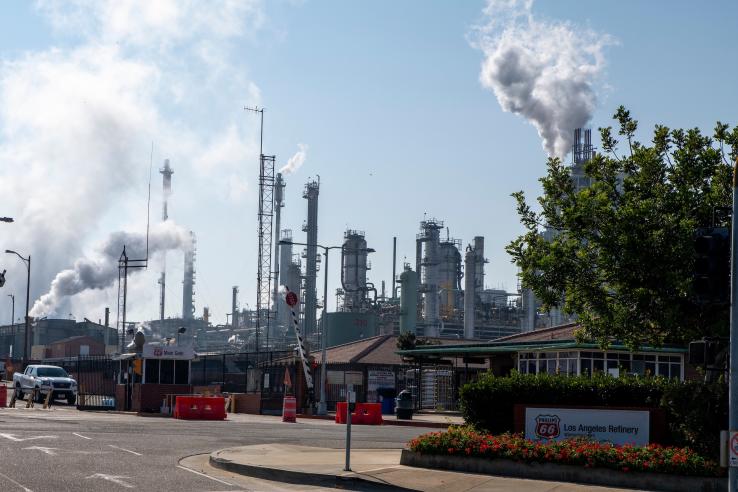 A factory participating in cap-and-trade program emits pollutants and emissions in the United States