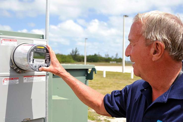 Professional pressing button on smart meter in an open space outdoors.