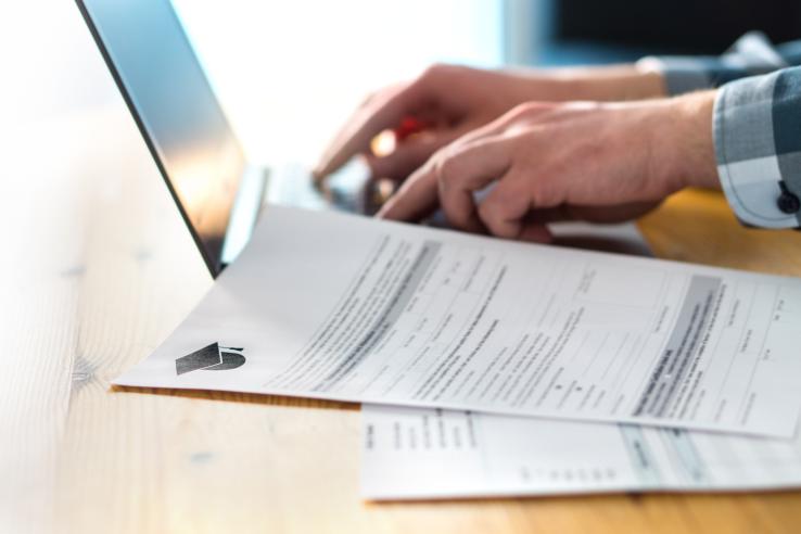 A close-up shot of someone using a laptop to fill out a college application.