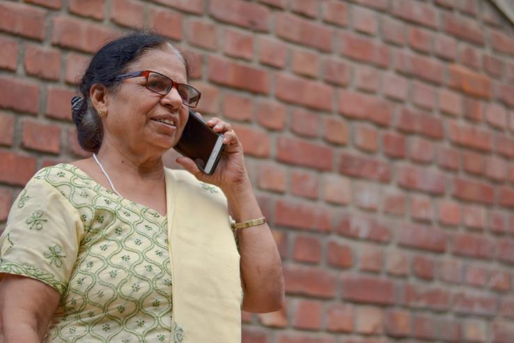 An older woman talks on her cell phone in India. 