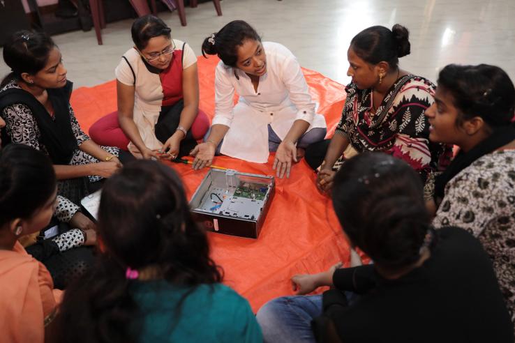 A group of seated women learning about computer hardware