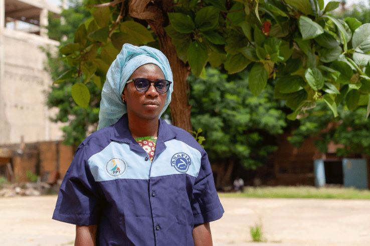 A female mechanic stands in uniform