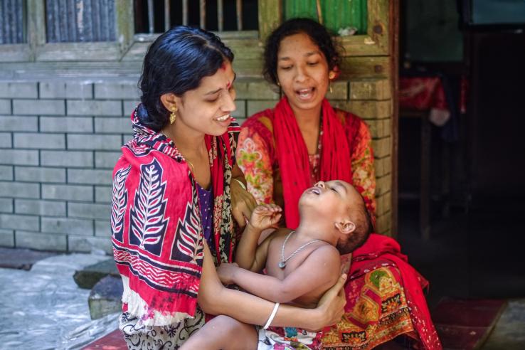 A smiling woman holding a child