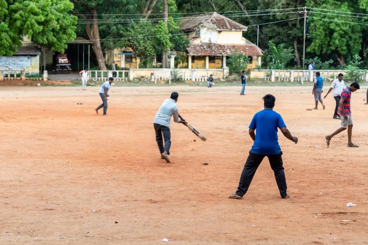 Men playing cricket. 