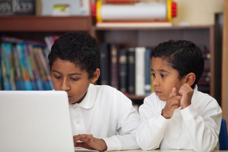 Students working together on a laptop.