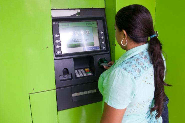A woman withdraws cash from an ATM