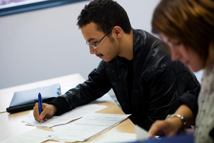 Man in glasses writes on papers