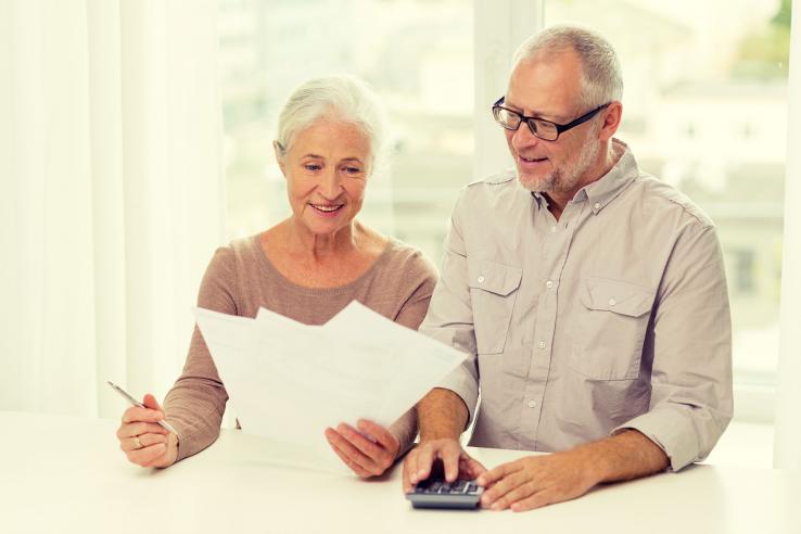 Older man and woman look at financial papers