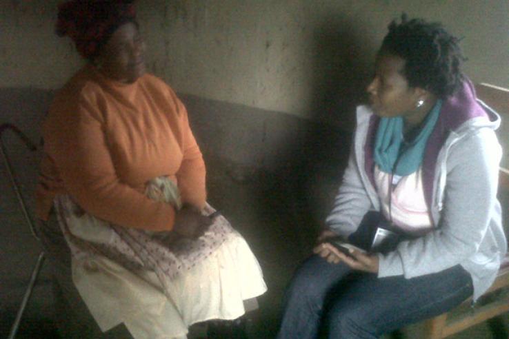 Two women in chairs talking inside house