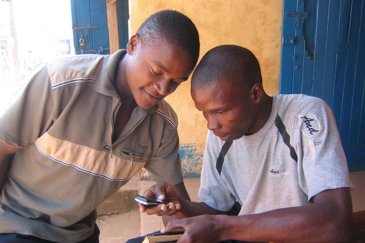 Two men look at mobile phone