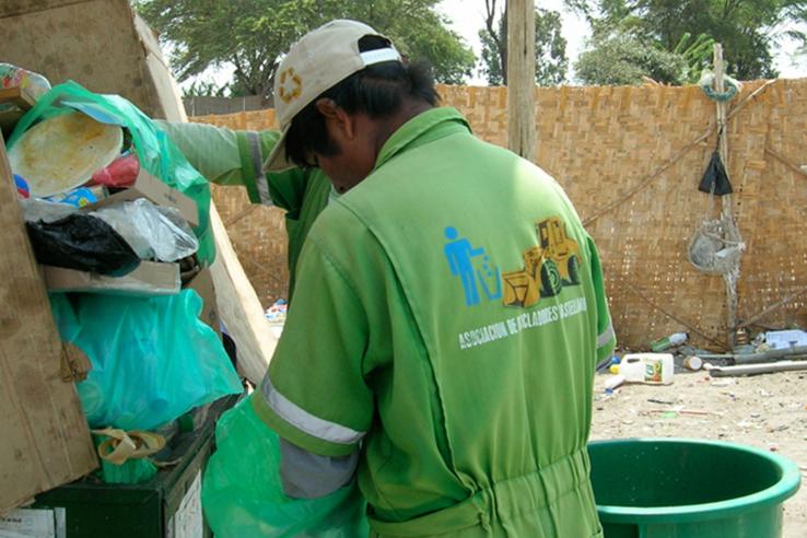 Man in jumpsuit puts recycling into truck