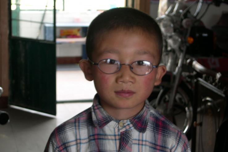 A schoolboy shows off his new glasses in Gansu Province, China.