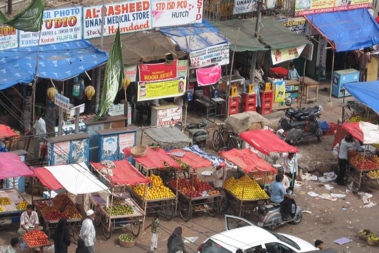 Street scene with fruit vendors and electronics stalls in Hyderabad, India