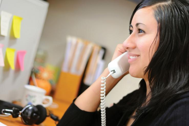 Smiling woman at work on the phone