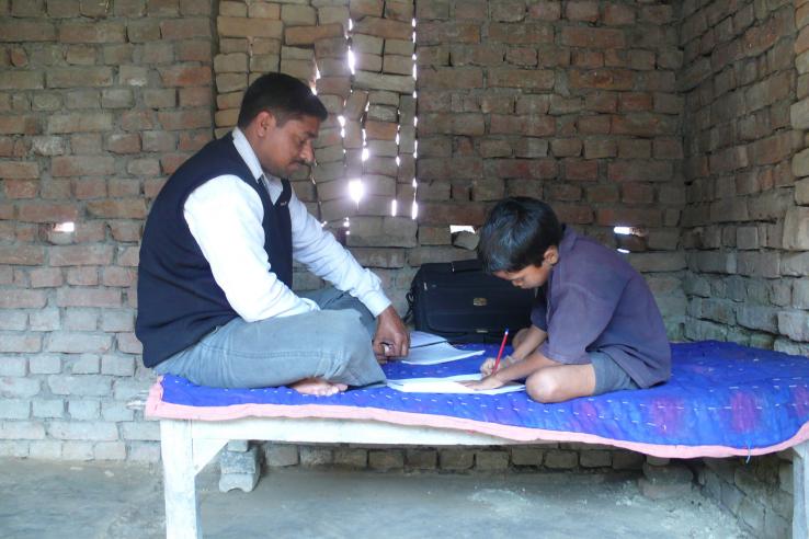 A father helps his son with his homework.