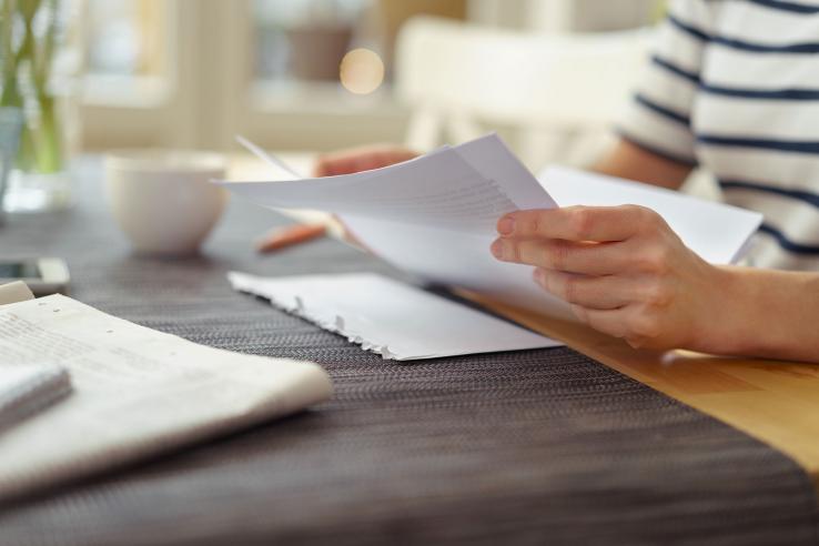 Hands hold a letter next to opened envelope