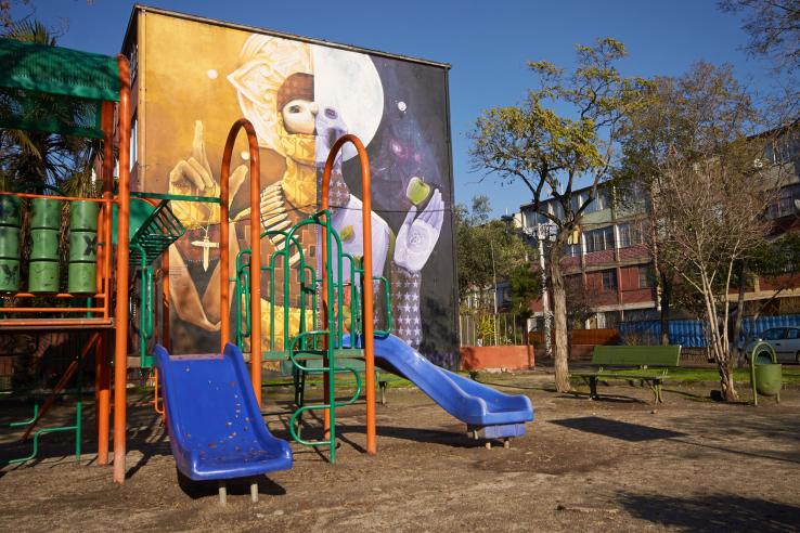 Playground in front of building with colorful mural