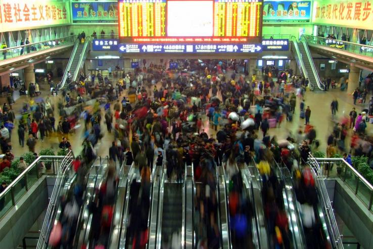 People use escalators in train station in China