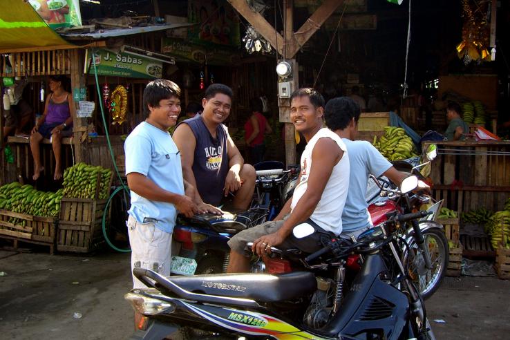 Smiling men in a market in the Philippines