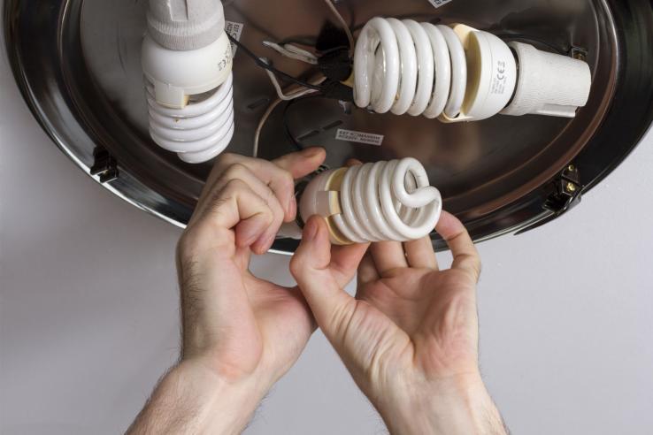 Electrician installing energy efficient lightbulbs