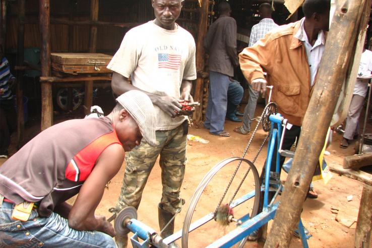 Men work on a bicycle in an open market
