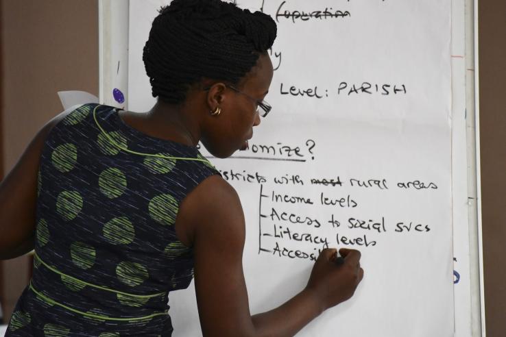 A woman writes on the board during the Evaluating Social Programs course in Kampala in 2018.