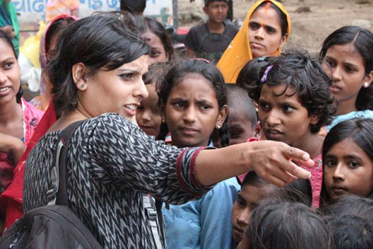 Woman pointing in front of crowd of children