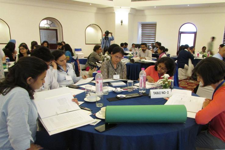 Participants at training sit around round table