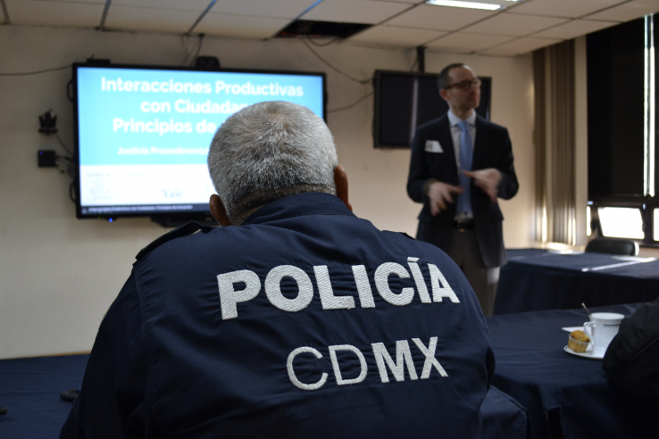 Man in suit gives presentation to policeman in Mexico City