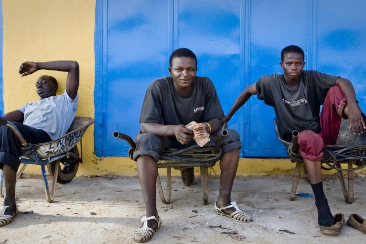 young men sitting in wheelbarrows