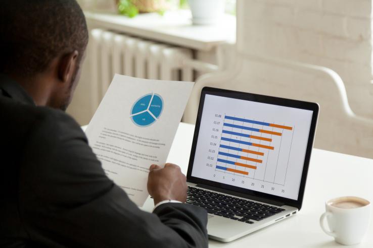 man looking at a pie chart and bar graph