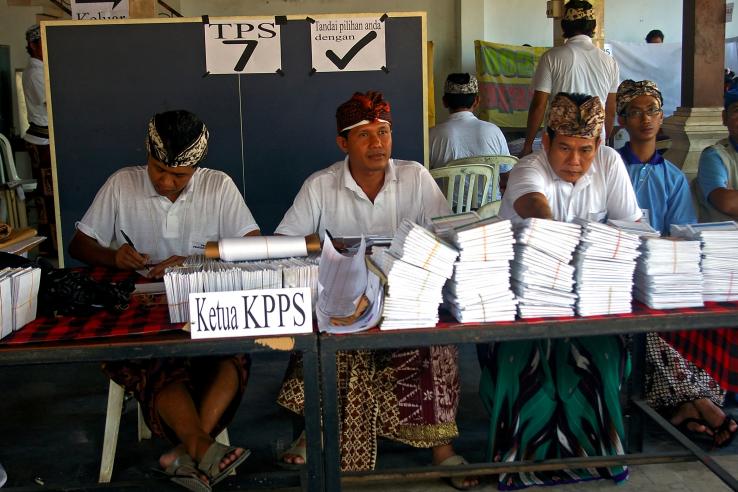 election officials with ballot papers in a polling station