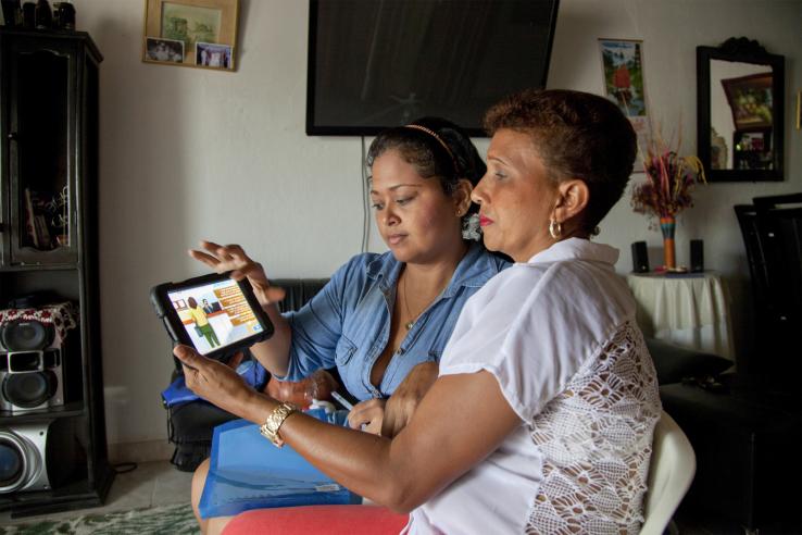 two women look at a tablet