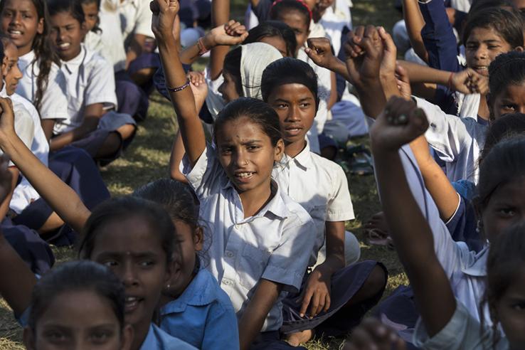 group of Indian school girls raising their hands