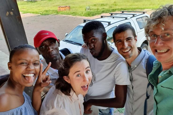 Six people smile pose for a casual group photo