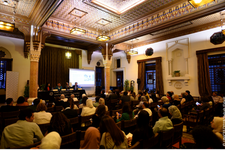 A crowd sits in a room at a conference at AUC.