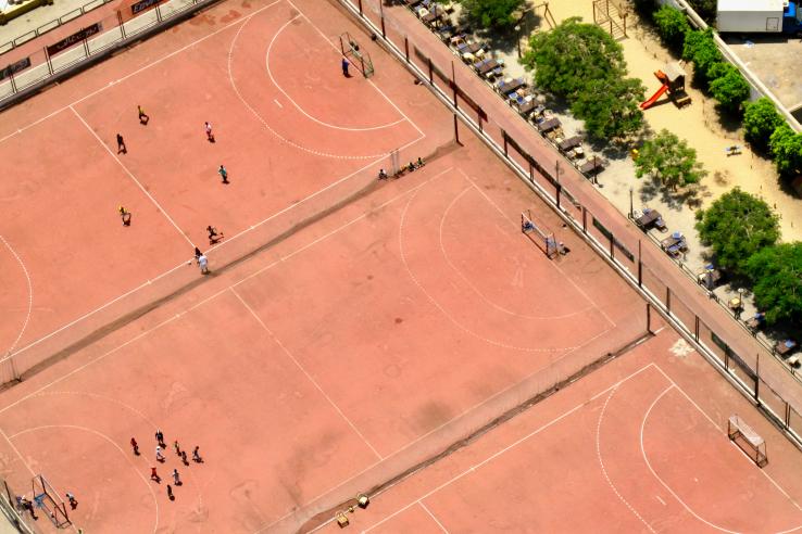 Three red soccer fields seen from far above 