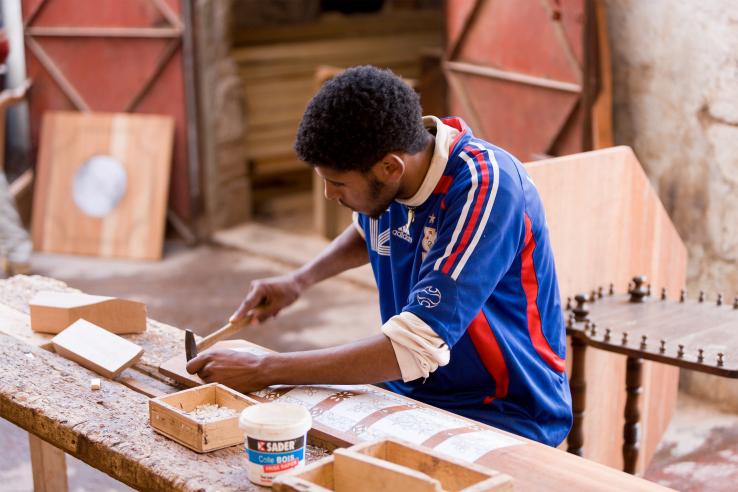 A man does woodworking in a workshop