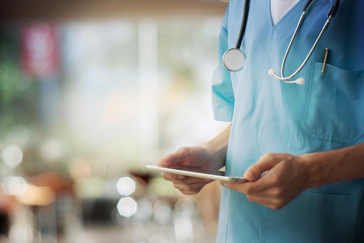 A medical professional holding a tablet