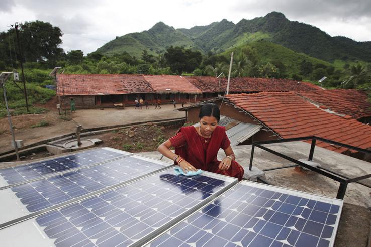 A woman cleans a solar panel.