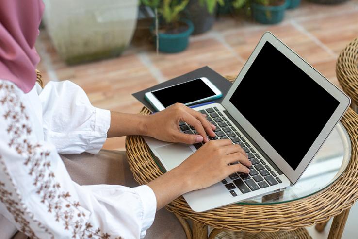 A woman types on a computer