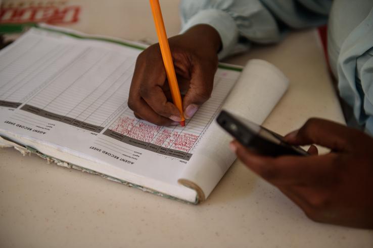 A person manages book of mobile cash transfers