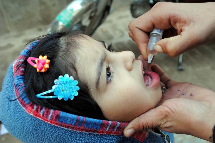 A young child receiving immunization drops