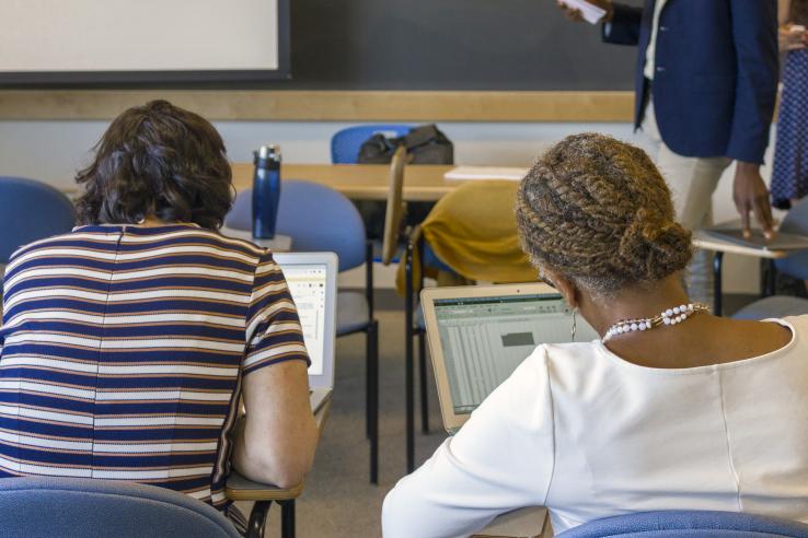 Participants at J-PAL's Evaluating Social Programs course working through an exercise on their computers.