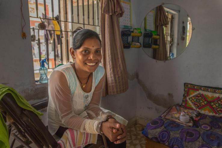 A woman sits and smiles