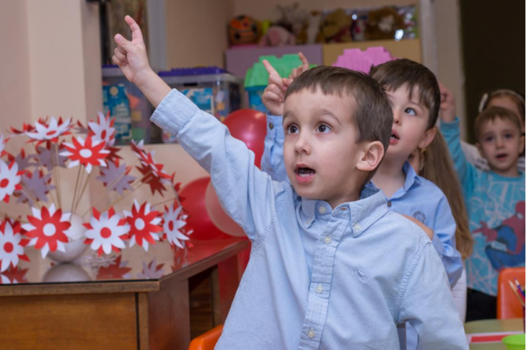 Young students raising their hands