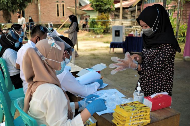 Poll workers wear personal protective gear outside of election sites in Indonesia in 2020.